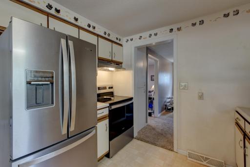 Past the kitchen is a second bedroom, a full bathroom, and a rear entryway that also provides a laundry space