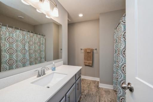 A full bathroom with oversized vanity services the rest of the bedrooms on the upper level. Vinyl plank flooring is warmer for your feet and easier on your knees than tile.