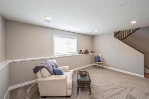 This bonus room in the lower level can be used as a guest bedroom or family room. Additional storage space and rough-in for a fourth bathroom are to the right.
