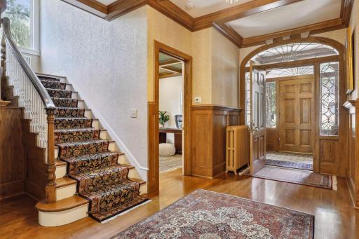 Step into the main hall to discover a beamed ceiling, gleaming hardwood floors, and paneling with lovely dentilwork trim.