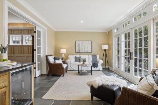 The slate floor sunroom seamlessly bridges the space between the living room to the dining room.