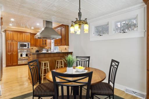 Decorative tin ceiling adds visual interest. A breakfast bar for meals-on-the-go can be found between the kitchen and breakfast room.