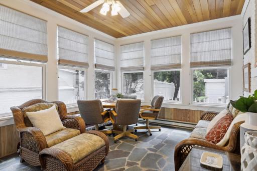 Watch the changing seasons or enjoy a cool summer breeze in the inviting porch, featuring windows on three sides, slate flooring, a wood ceiling, corner cabinets, and walk-out to the side yard and a cozy deck.