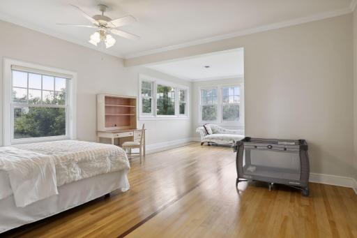 The fourth bedroom on the second level has walls of windows, three closets, and hardwood floors with inlaid trim.
