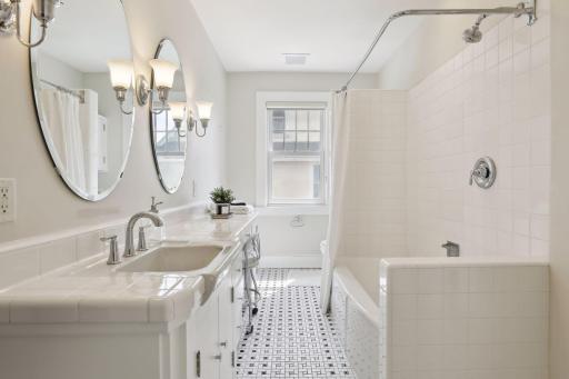 There is a ceramic tiled full bath bath with cozy heated floors nearby.