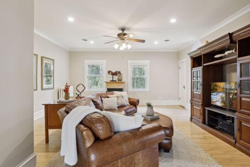 The handsome family room boasts a three-sided gas fireplace, a ceiling fan, a walk-in closet, and windows with treetop views.