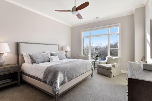 Spacious primary suite is filled with light