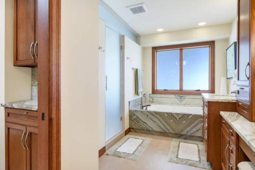 Primary Bathroom with River Jade Marble, custom cabinetry, in-floor heat