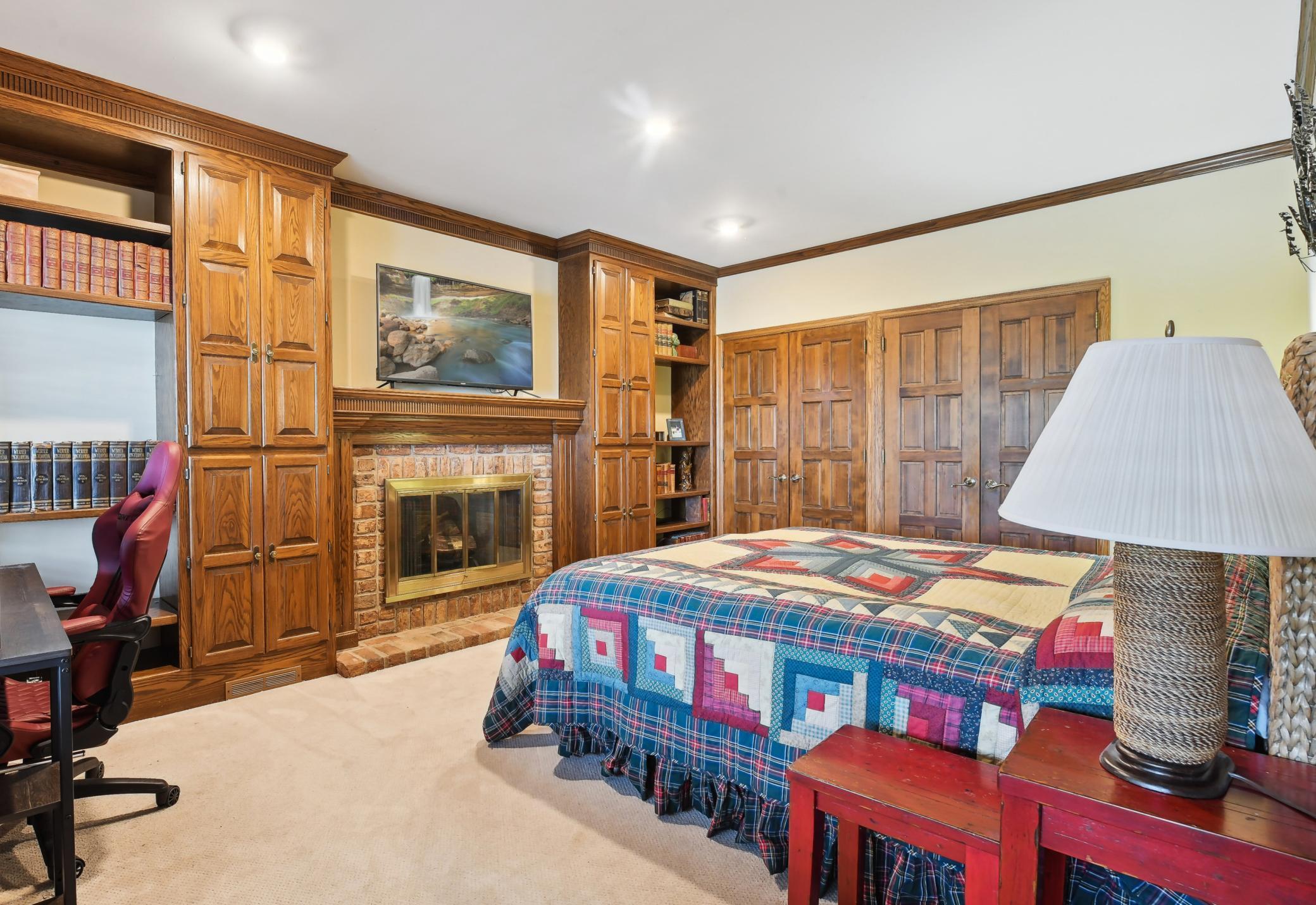 The lower level fifth bedroom would also be a great den/office showcasing a fireplace flanked by built-ins. The large wall closet is deep and offers built-in organizers.