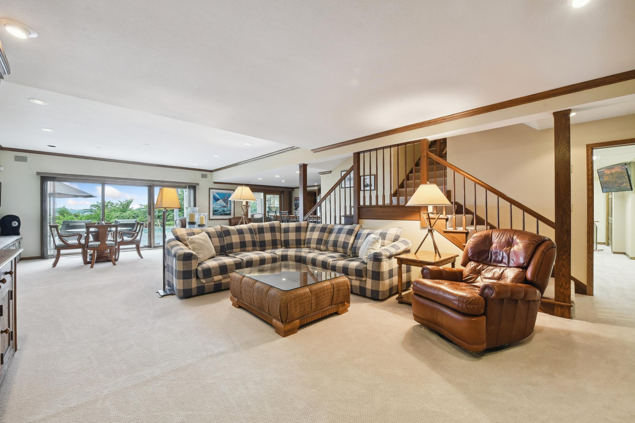An oversized sliding glass door fills the room with natural light, and offers easy access to the lake side pool area.