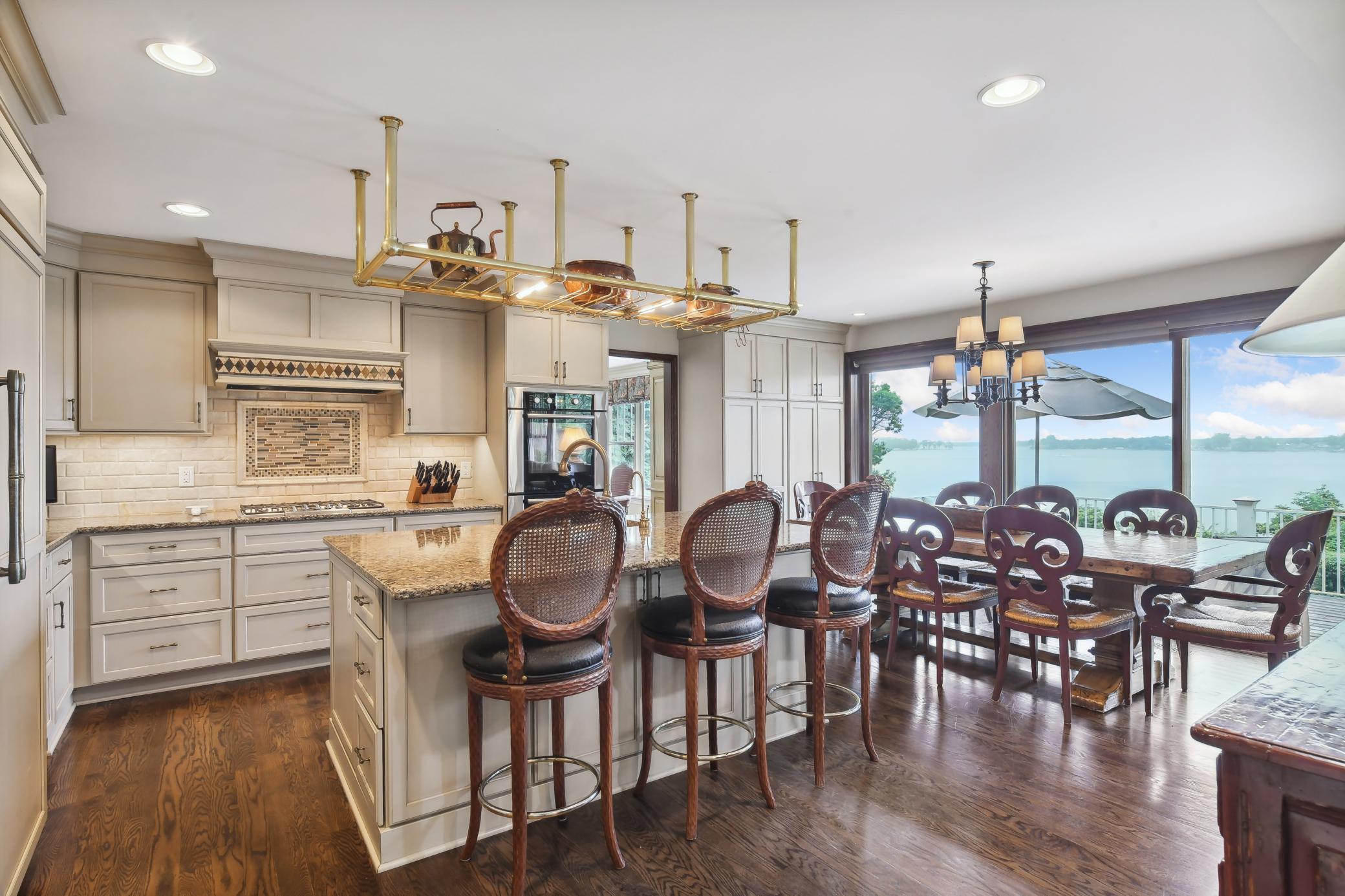 Beautifully appointed, the kitchen features custom cabinetry with ample storage space, granite counters, tile backsplash and high-end appliances.
