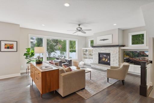Stone fireplace and custom built-ins in the living room overlooking backyard.