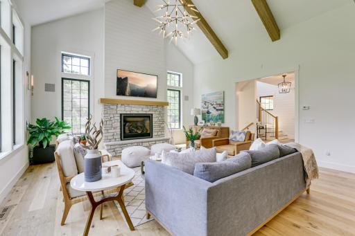 Photo of previously built home. Spectacular great room is the central focal point of the home featuring soaring 14 ft. vaulted ceilings with wood beam accent, oversized windows with backyard views and a cozy gas fireplace.