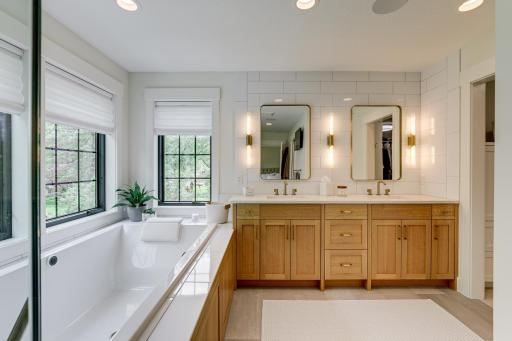 Photo of previously built home. Luxurious spa-like Owner's bath offers dual sinks with quartz countertop, tile flooring with in-floor heat, built-in speakers and separate commode.