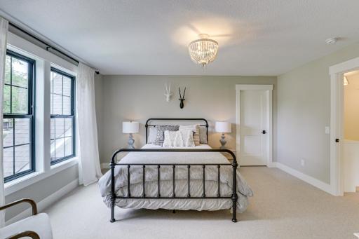 Photo of previously built home. Upper level presents 3 additional spacious bedrooms. This bedroom offers large picture windows, walk-in closet and private en-suite 3/4 bathroom.