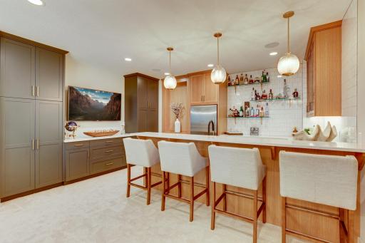 Photo of previously built home. Entertain in style at remarkable wet bar features a full suite of stainless-steel appliances and custom soft closed white oak cabinets with under cabinet lighting.