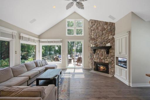 One of the 4 gas burning fireplaces in the home. Glass doors lead you out to the deck and screened porch.