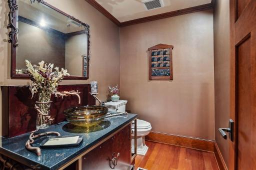 Adjacent to the kitchen, you'll discover the half bath with custom-crafted architectural-bronze vanity.