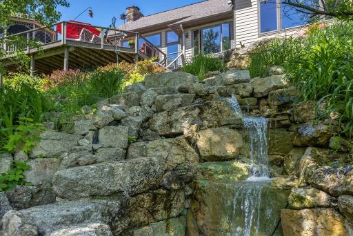 Exterior Of Home And Water Feature Adjacent to Lower Level Patio