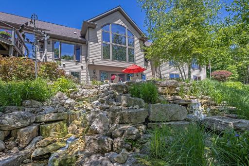 Exterior Of Home And Water Feature Adjacent to Lower Level Patio