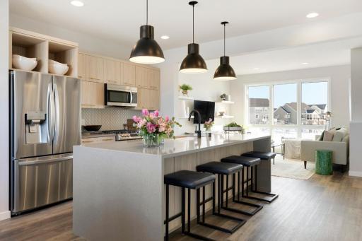 Kitchen features LG stainless appliances, spacious waterfall quartz island, and high lift cabinets. Photos are of model home; features and options may vary.