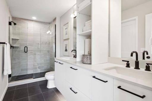 Ceramic tile shower walls and shower floor with full glass door. Spacious vanity with double sinks and lots of storage.