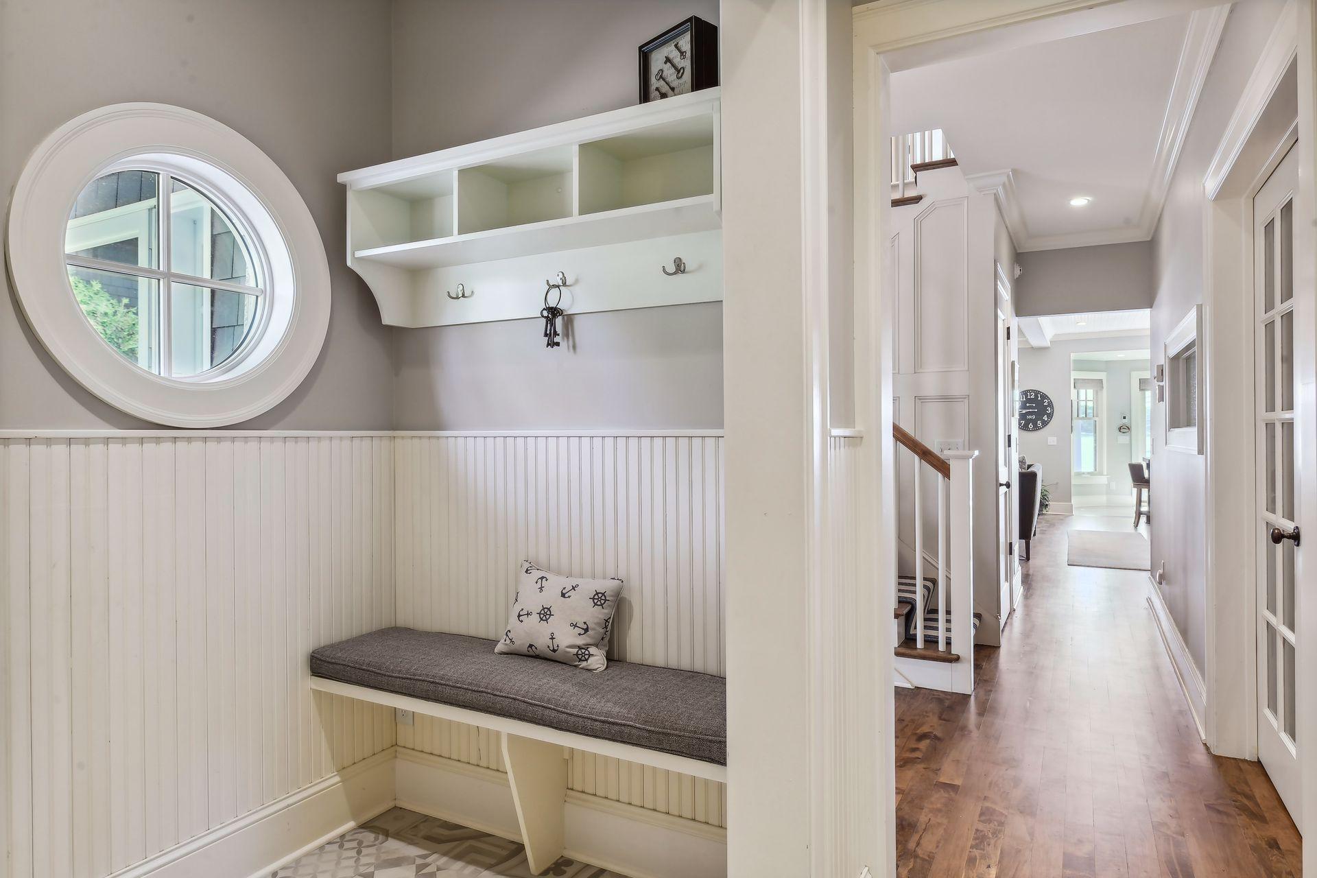 Just off the garage is the Mud Room that features a built-in boot bench, enameled beadboard wainscoting and a wall of built-in cabinetry.