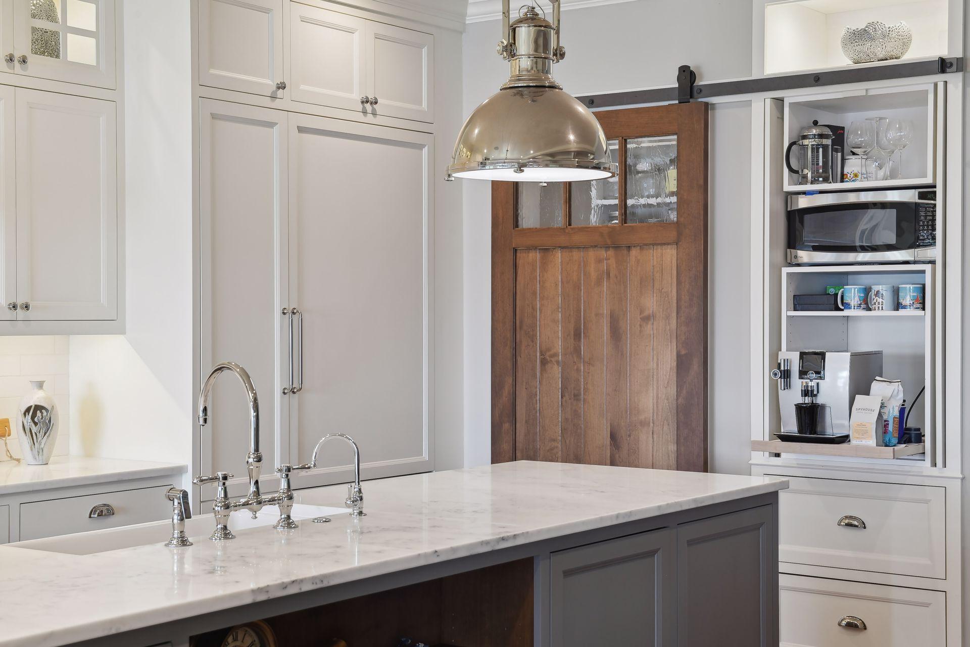 The Kitchen is equipped with Miele and Viking appliances. Tucked away behind the custom barn door is the Kitchen Pantry and the convenient appliance cabinet is perfect for your coffee machine and microwave.
