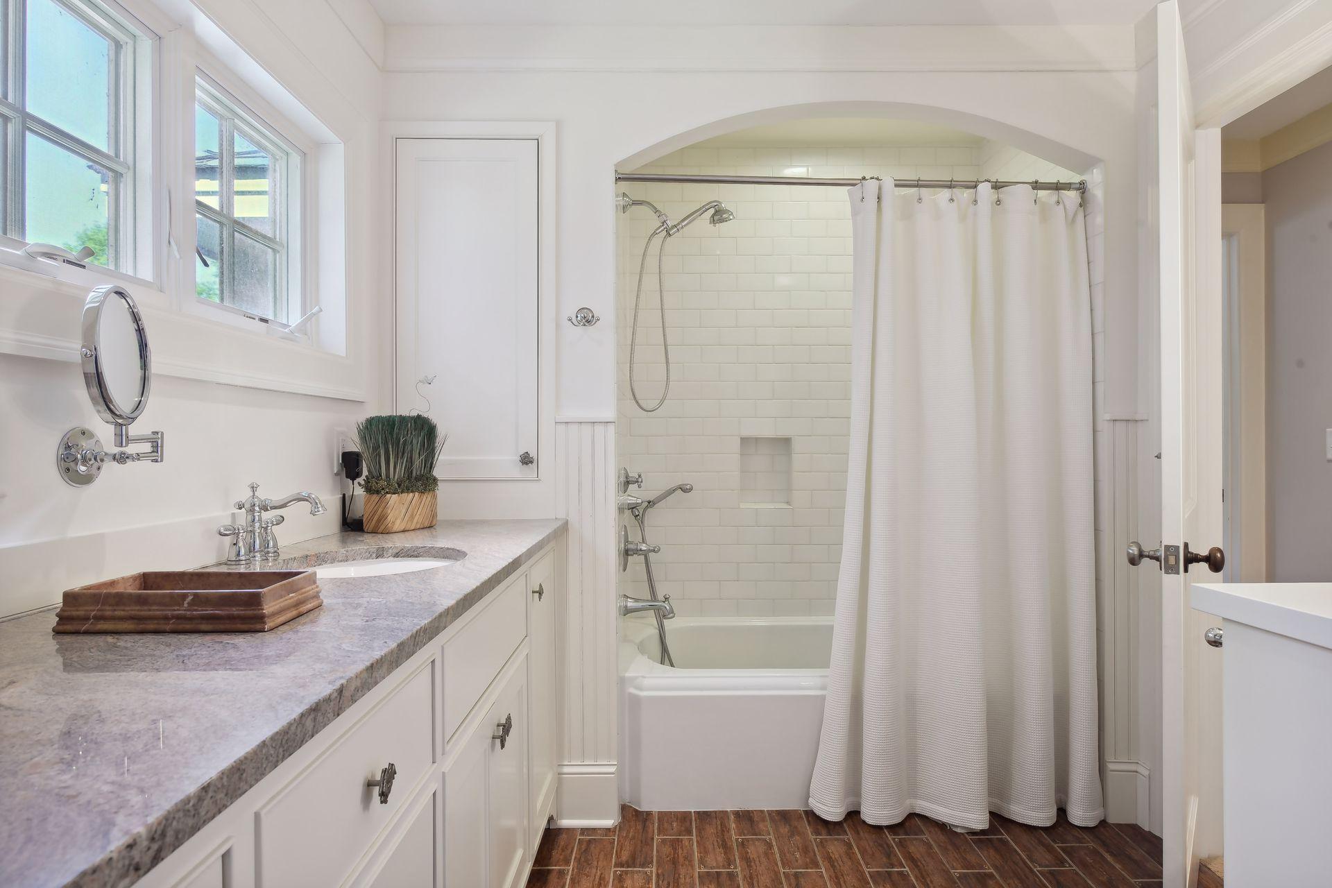 This full, walk-through bathroom offers tons of charm with subway tiled shower and tub surround and beautiful tiled flooring.