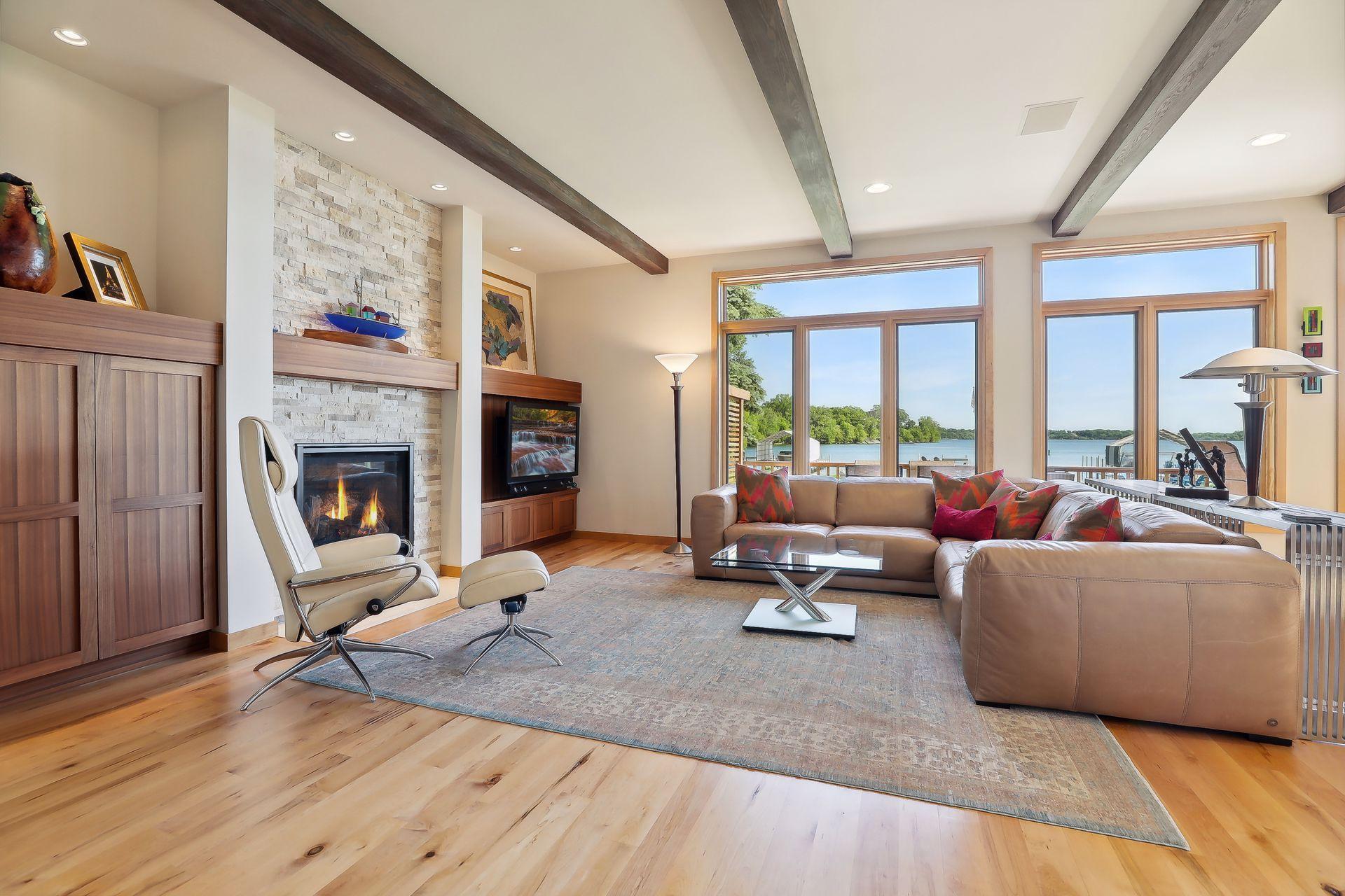 Inviting great room features a gas fireplace, wood beam ceiling accents