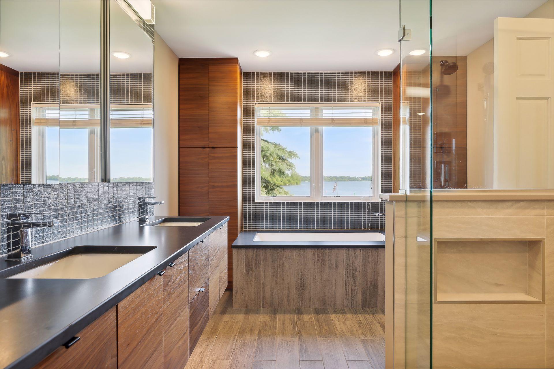 Spa like primary bath with dual sinks, soaking tub, and walk-in shower