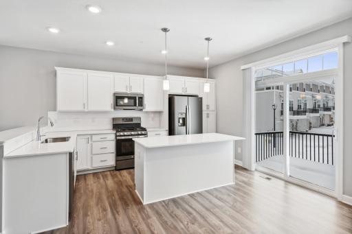 Beautiful kitchen with easy access to a private deck. Photos are not of actual home. Actual home will be similar. Some colors and features may vary.