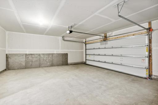Large 2 car garage with additional space for shelving or storage. Photos are not of actual home. Actual home will be similar. Some colors and features may vary.