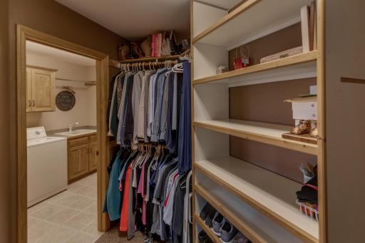 Primary suite walk-in closet, with walk-through to laundry.