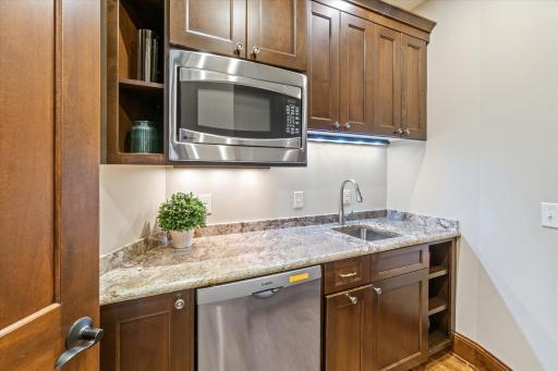 Butler's pantry with dishwasher, microwave, refrigerator, and pantry