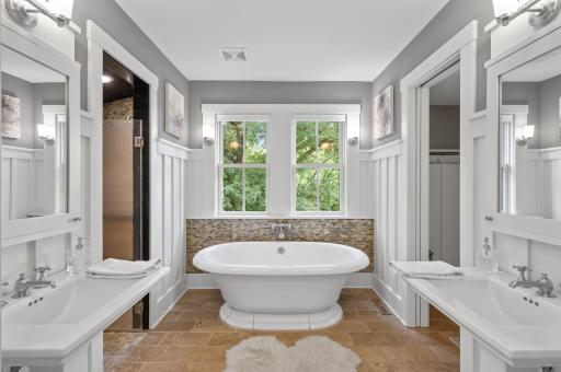 The bathroom features a large standalone tub, providing a luxurious and relaxing bathing experience. This tub serves as a focal point in the room and invites indulgence and tranquility.
