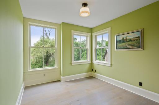 The bedroom is adorned with three oversized windows, allowing an abundance of natural light to fill the space. These large windows also offer panoramic views of the wetlands
