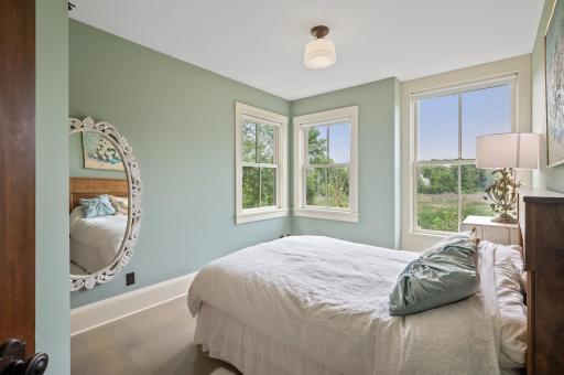 The bedroom is adorned with three oversized windows, allowing an abundance of natural light to fill the space. These large windows also offer panoramic views of the wetlands.