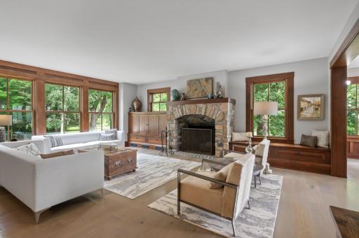 The focal point of the room is a wood-burning fireplace with a custom wood mantle. The fireplace is surrounded by a stone frame, adding a rustic and natural touch to the space.