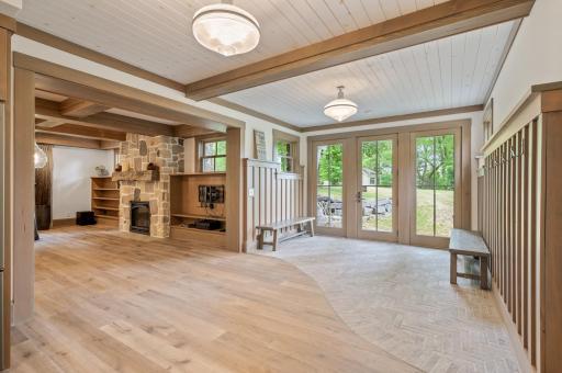 This entryway from the backyard into the basement combines the beauty of natural light through the oversized windows with practical features such as benches for storage and recessed lighting.