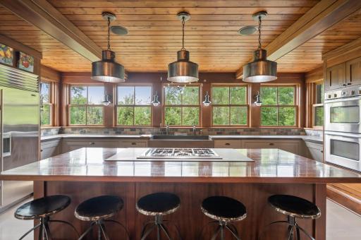 The kitchen is illuminated by hanging light fixtures, adding a stylish and functional lighting element to the space.