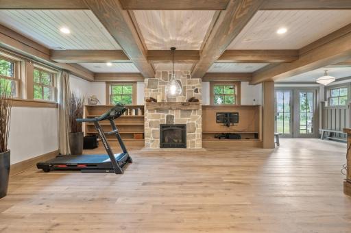 Above the fireplace, there is a custom barn beam mantle, which adds a decorative element to the room.