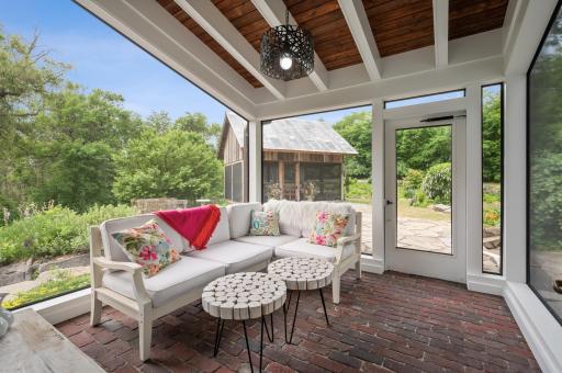 The screened porch is a delightful and scenic space, offering stunning views and a unique touch with its repurposed brick floors brought in from Lake Street in Minneapolis.