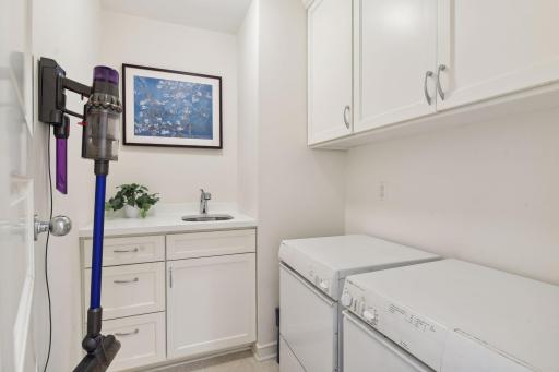 The laundry room is a real step-saver, with a washer, dryer, sink, and storage cabinets.