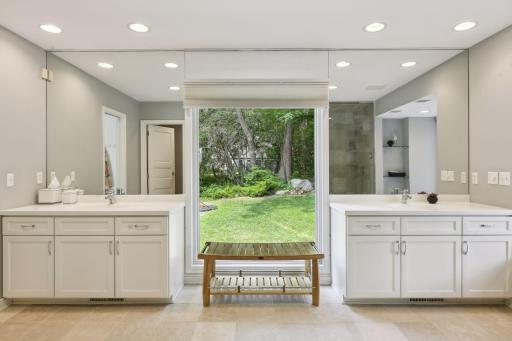 The owner's bath is luxurious and sparkling, with tiled flooring, wonderful windows, and dual vanities.