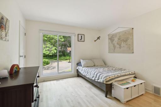 A second bedroom on the main level is bright and functional with hardwood floors, sliders to the patio, and a generous walk-in closet.