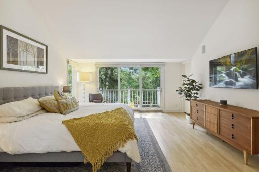 Find hardwood floors, vaulted ceiling and a wall of windows with patio doors to a private deck.