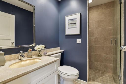 A three-quarter bath with vanity and tiled shower can be found mere steps away.