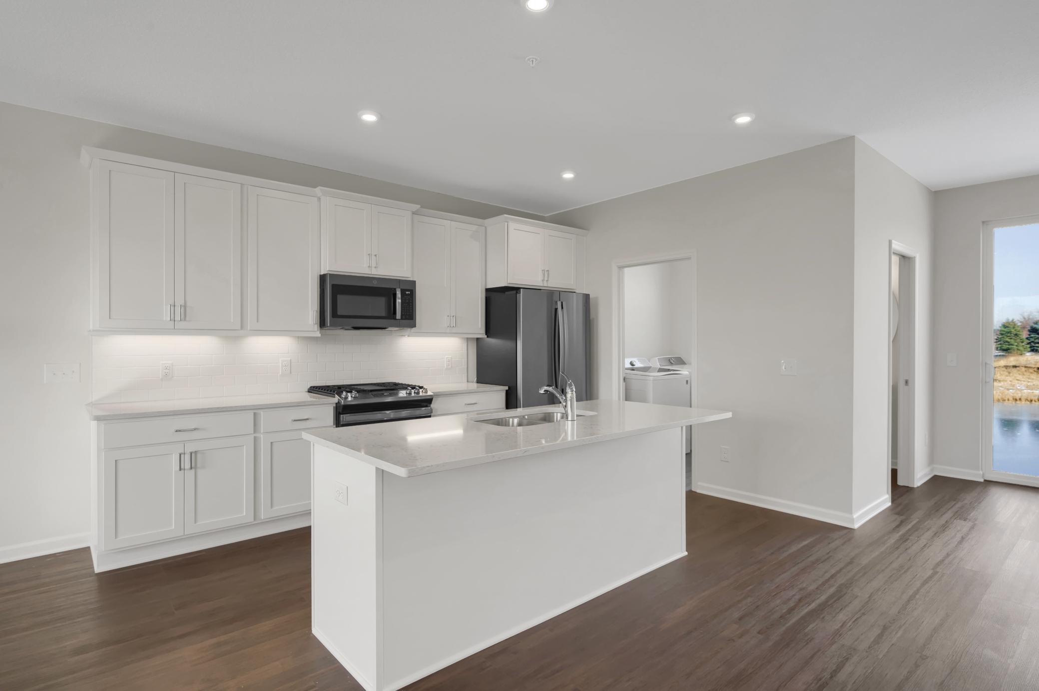 Photo for 6675 Jody Avenue S, Cottage Grove, MN 55016 - Listing #6382915 Main floor kitchen. White cabinets with undercabinet lighting and a ceramic tile backsplash.