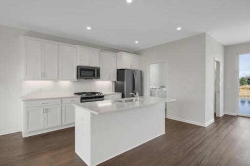 Main floor kitchen. White cabinets with undercabinet lighting and a ceramic tile backsplash.